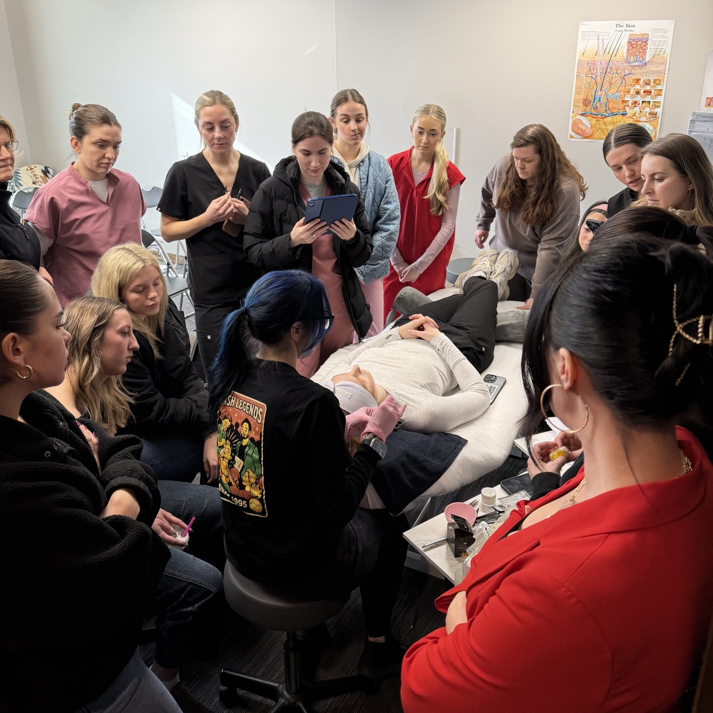 Students gathered around a model during an in-person Elleebana certification class