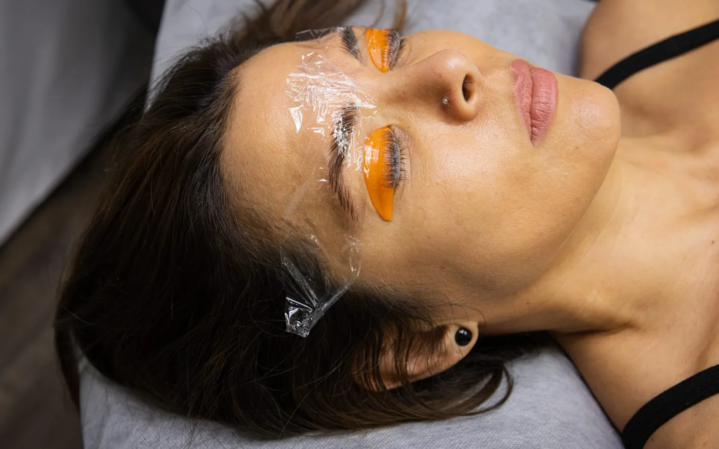 Brows set under lamination wrap, with lashes lifting on shields.